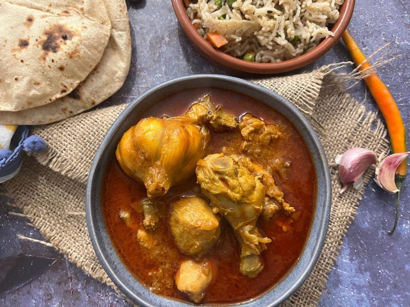 Chicken handi curry served with tawa roti and vegetable pulao